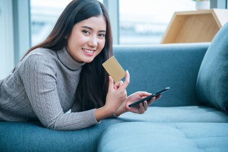 Women crazy shopaholic holding shopping bags , money ,credit card person at shopping malls.Fashionable Woman love online website with sales tag on black friday. E-commerce digital marketing lifestyleの写真素材