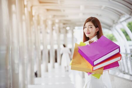 Shopaholic Women holding shopping bags ,money ,credit card person at shopping malls.Fashionable Woman love online website with sales tag on black Friday. E-commerce fashion digital marketing lifestyleの写真素材