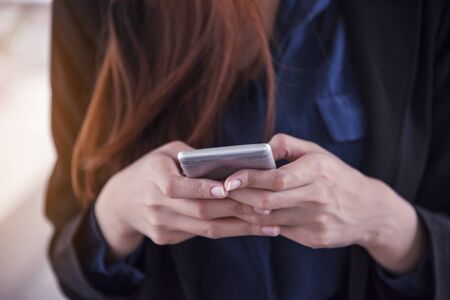 Asian woman using shopping online website on smartphone with smiling face. Happiness asian woman holding cellphone checking mail from online shopping website read article Blog vlog social mediaの写真素材