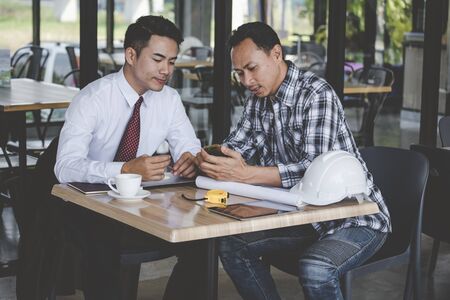 Construction engineer team meeting in construction Site businessman consult with contractor. Business conference Hard Hat, Blueprint on table for Civil Construction Engineer. Engineering Conceptの写真素材
