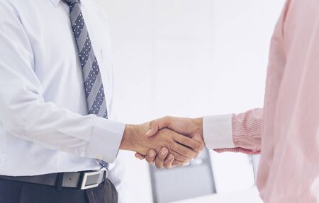 Team Business Partners shaking hands together to Greeting Start up new project. Shakehand Teamwork Partnership outside office modern city background. Businessman handshake together.  Business conceptの写真素材