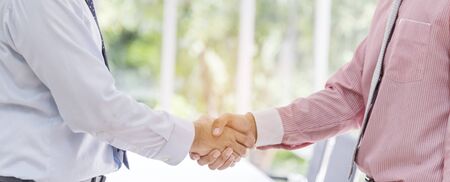 Team Business Partners shaking hands together to Greeting Start up new project. Shakehand Teamwork Partnership outside office modern city background. Businessman handshake together.  Business conceptの写真素材