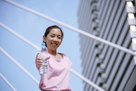 Sport Fitness Women drinking mineral water after running exercise modern city wear wellness sportswear outside. Young woman workout outdoor exercising outside. Healthy wellness lifestyle woman conceptの写真素材
