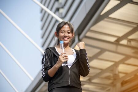 Sport Fitness Women running exercise in modern city wear wellness sportswear outside. Young woman workout outdoor exercising on bright sunny outside. Healthy wellness lifestyle woman concept.の写真素材