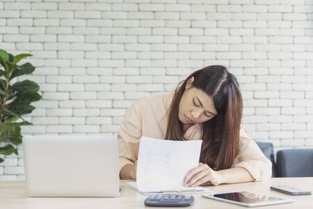 Work from home conceptual woman working on laptop at home cause   covid-19  epidemic  infection. Asian woman connect internet working at home office wireless internet technologyの写真素材