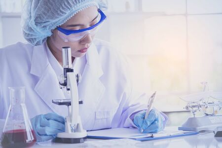 Female scientist look at microscope, science test tube analyse scientific sample in laboratory...