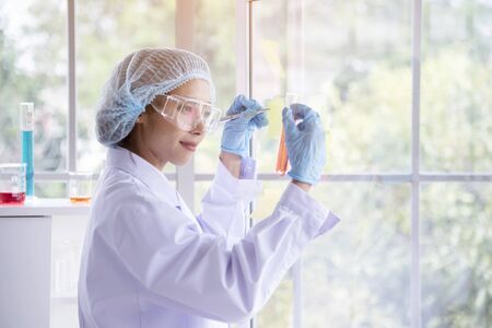 Female scientist look at microscope, science test tube analyse scientific sample in laboratory research experiment biotech make cultivate vaccine against virus. Chemistry science laboratory conceptの写真素材