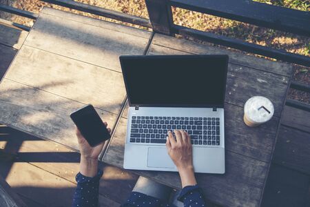 Happy entrepreneur asian business woman using smartphone laptop dealing negotiate with customer for startup business enjoy good news from email online marketing with dealer merchant. Start up businessの写真素材
