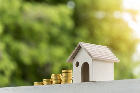 Investment buy house property home loan mortgage advice real estate marketing interest asset with golden money coin stack.Saving Money Concept. Woman hand holding budget buy house real estate agent.の写真素材