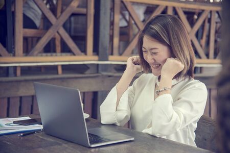 Work from home conceptual woman working on laptop at home cause of coronavirus covid-19 world epidemic virus infection. Asian woman connect internet working at home office wireless internet technologyの写真素材