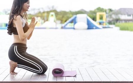 Yoga fitness lifestyle healthy woman relaxation doing a meditation. Yoga meditating outdoor with zen on sitting position. Young exercise concept.の写真素材