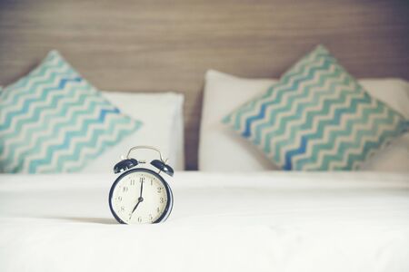 alarm clock on bed in luxury bedroom in hotelの写真素材