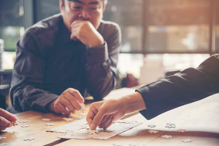 Implement improve puzzel solve connections together with synergy strategy team building organizing connection by trust communication. Hands of stakeholders business trust team holding jigsaw puzzleの写真素材