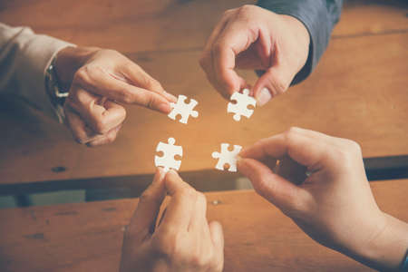 Implementation improving connections strategy team solution organization.Piece of jigsaw assembly by Implement puzzle. Hands of team connecting group of business people solutions success strategyの写真素材