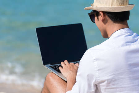 Busy freelance man with laptop outdoor.  Businessman corporate city life outside with lifestyle technology. Handsome man connect internet outdoor on the beach. Internet technology lifestyle concept.の写真素材