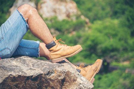 Hiking walk on mountain with trekking brown boots explorer on rock mountain view. Adventure man...