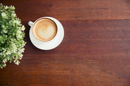 Coffee cup and small tree decorate on wooden table with copy space. Background banner for coffee...