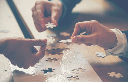 Implement improve puzzel solve connections together with synergy strategy team building organizing connection by trust communication. Hands of stakeholders business trust team holding jigsaw puzzleの写真素材