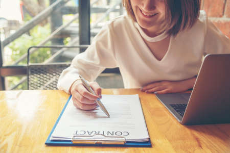 Beautiful business woman using pen signing on new contract to starting projects.  working woman work outdoor. business concepts.の写真素材