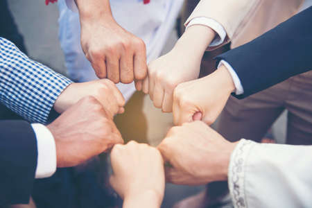 Group of diversity people with success partnership fist bump of hands together to show power and unified teams in office. Business teamwork trust in partner. Teamwork Concept.の写真素材