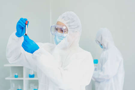 Scientist covid-19 virus antibody research laboratory research experiment biotech cultivate vaccine against virus. Scientist look at microscope experiment lab science test tube Chemistry laboratoryの写真素材