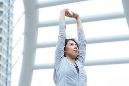 Sport Fitness Women running exercise in modern city wear wellness sportswear outside. Young woman workout outdoor exercising on bright sunny outside. Healthy wellness lifestyle woman concept.の写真素材