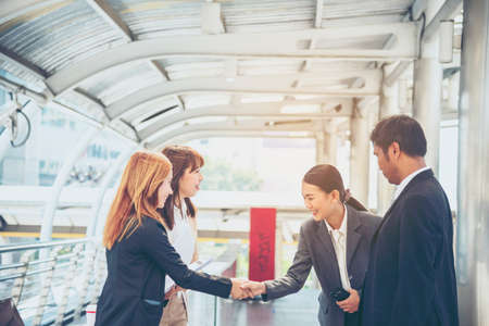 Team Business Partners shaking hands together to Greeting Start up new project. Shakehand Teamwork Partnership outside office modern city background. Businessman handshake together.  Business conceptの写真素材