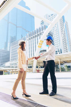 Civil Construction engineer teams shaking hands together wear work helmets worker on construction site. Foreman industry project working engineer teamwork. Two asian engineer team shake hands togetherの写真素材