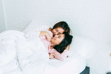Lesbian couple homosexual happiness lifestyle on bed. Two pretty girlfriend talk, hug and laugh...
