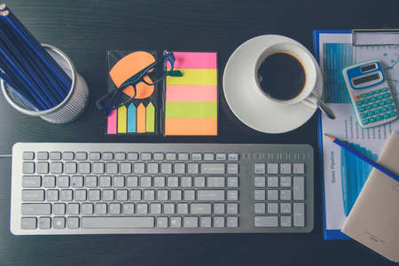 Office laptop business financial document chart and graph on wooden table with coffee cup. Flat lay...