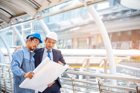 Construction engineer in Safety Suit Trust Team Holding White Yellow Safety hard hat Security...