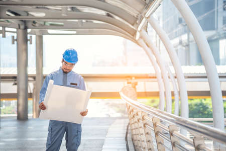 Construction engineer in Safety Suit Trust Team Holding White Yellow Safety hard hat Security Equipment on Construction Site. Hardhat Protect Head for Civil Construction Engineer. Engineering Conceptの写真素材