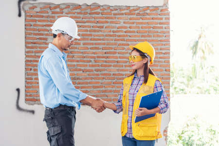 Civil Construction engineer teams shaking hands together wear work helmets worker on construction...