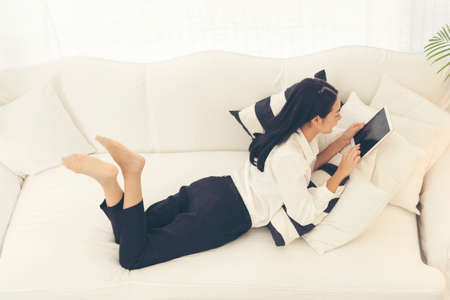 Asian woman using ipad shopping online website on smartphone with smiling face. Happiness asian woman holding cellphone checking mail from online shopping website read article Blog vlog social mediaの写真素材