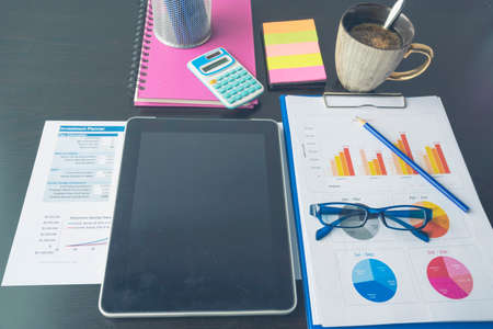 Office laptop business financial document chart and graph on wooden table with coffee cup. Flat lay notebook computer laptop on office desk. No people business graph chart mockup on business workspaceの写真素材