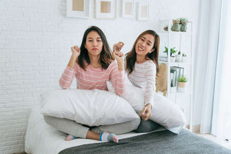 Two pretty best friends forever girlfriend talk, hug and laugh together on bed at cozy home relation fall in love. Lesbian couple homosexual happy lifestyle on bed. LGBTQ relation lifestyle concept.の写真素材