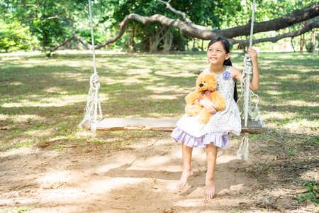 Happy Child hug teddy bear in green park playground. Teddy bear best friend for little kids cute girl. Autism happy funny playing together on playground in happiness family feel love and warm hugsの写真素材
