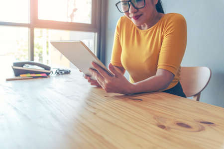 Young start up business woman working enjoy good news from smartphone. Asian Business people working at home office with happinessの写真素材