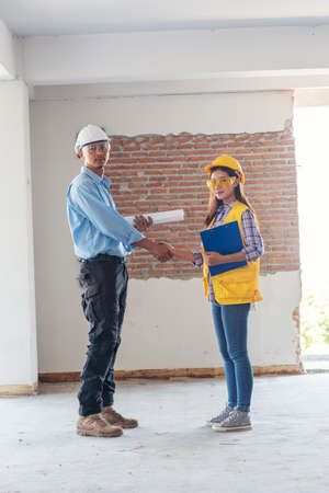 Civil Construction engineer teams shaking hands together wear work helmets worker on construction...