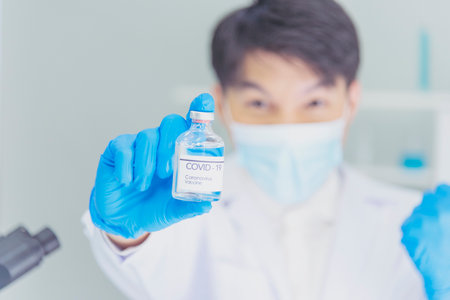 Scientist covid-19 virus chemistry  research experiment biotech antibody sample laboratory cultivate vaccine against virus. Scientist look at microscope, science test tube analyse Chemistry laboratoryの写真素材