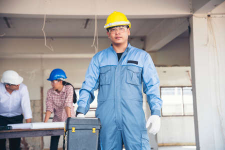Construction engineer teamwork Safety Suit Trust Team Holding White Yellow Safety hard hat Security Equipment on Construction Site. Hardhat Protect Head for Civil Construction Engineer Conceptの写真素材