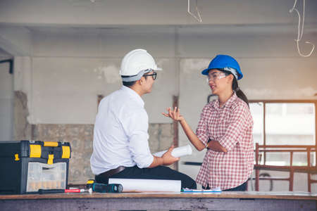 Construction engineer teamwork Safety Suit Trust Team Holding White Yellow Safety hard hat Security Equipment on Construction Site. Hardhat Protect Head for Civil Construction Engineer Conceptの写真素材