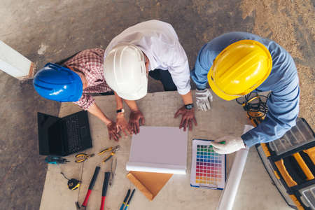 Construction engineer teamwork Safety Suit Trust Team Holding White Yellow Safety hard hat Security Equipment on Construction Site. Hardhat Protect Head for Civil Construction Engineer Conceptの写真素材