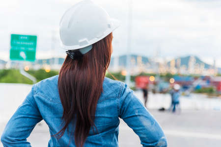 Woman engineer entrepreneur construction industry worker. Female engineer working refinery oil plant manufacturing. Young civil engineering construction wear hard hat safety helmet construction site.の写真素材