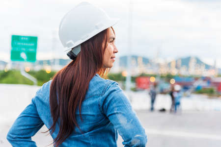 Woman engineer entrepreneur construction industry worker. Female engineer working refinery oil plant manufacturing. Young civil engineering construction wear hard hat safety helmet construction site.の写真素材