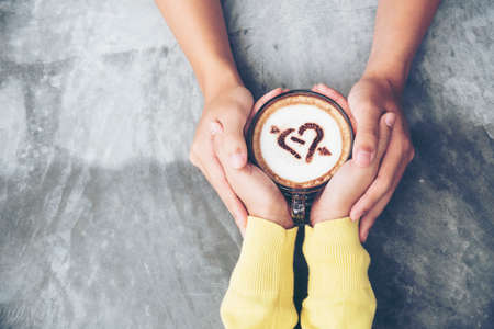 Couple lover having date and drinking a cup of coffee together. happy relation on cafe. coffee lover concept. Close up woman hands holding cup of coffee. Drinking coffee make people freshnessの写真素材