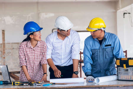 Construction engineer teamwork Safety Suit Trust Team Holding White Yellow Safety hard hat Security Equipment on Construction Site. Hardhat Protect Head for Civil Construction Engineer Conceptの写真素材
