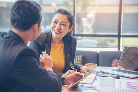 Happiness diversity business team meeting corporate office desk in company meeting room. Asian team group partner brainstorming discussion multiethnic people sitting share ideas teamwork in boardroomの写真素材
