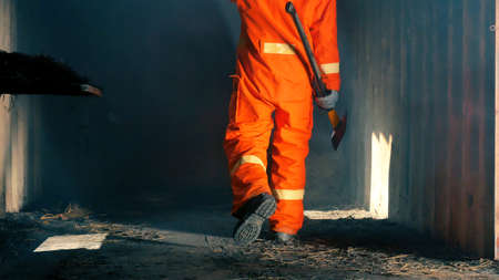 Firefighter fighting with flame using fire hose chemical water foam spray engine. Fireman wear hard hat, body safe suit uniform for protection. Rescue training in fire fighting extinguisherの写真素材
