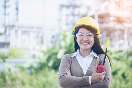 Construction engineer in Safety Suit Trust Team Holding White Yellow Safety hard hat Security Equipment on Construction Site. Hardhat Protect Head for Civil Construction Engineer. Engineering Conceptの写真素材